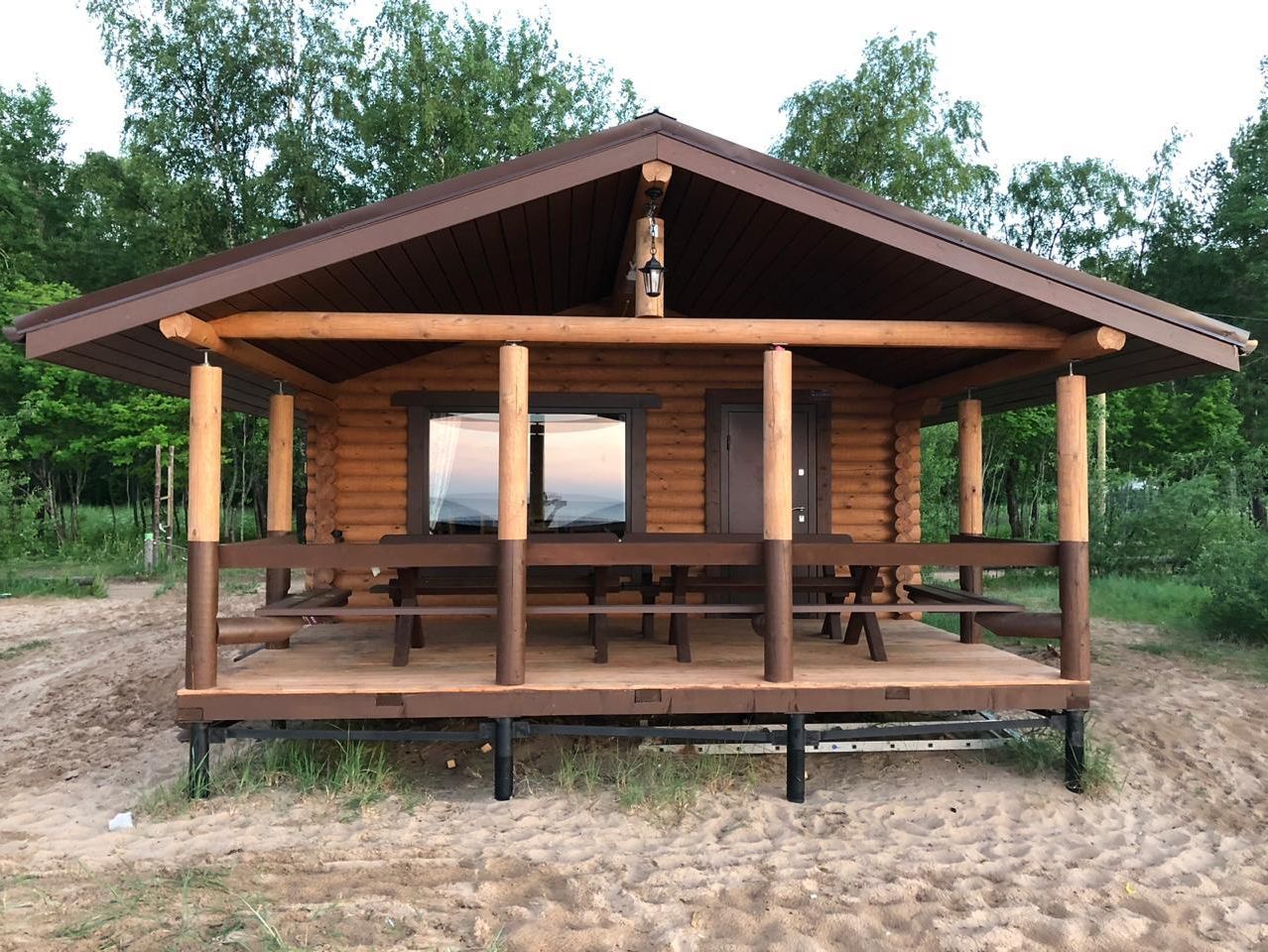 Интерьер веранды с большим столом и диванами